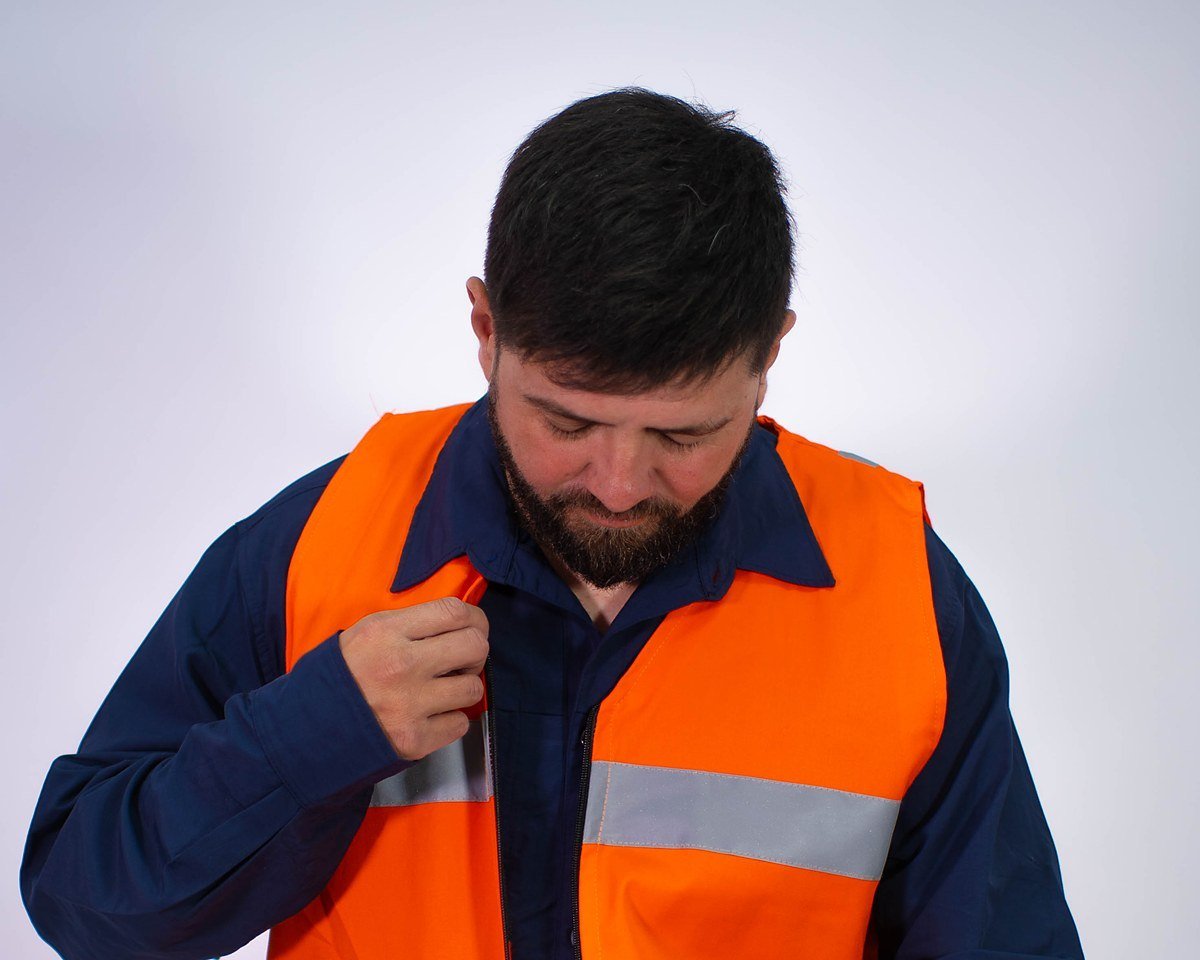 Operario cerrando un chaleco de alta visibilidad Big North sobre camisa de trabajo